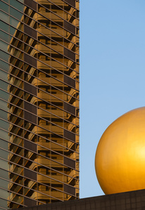 Geometric architectural shapes of the Asahi Beer Hall building by Philippe Starck stand out against the blue sky in Tokyo.