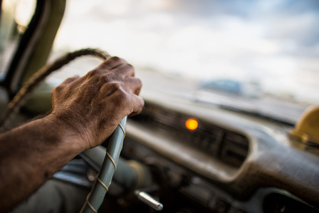 Interior view of an Oldsmobile 98 being driven around the Malecon in Havana.