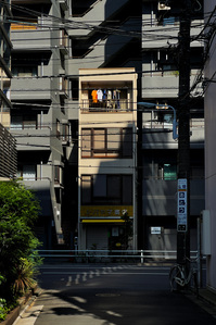 A beige coloured residential building between light and shadow somewhere in the Taito neighbourhood of Tokyo.