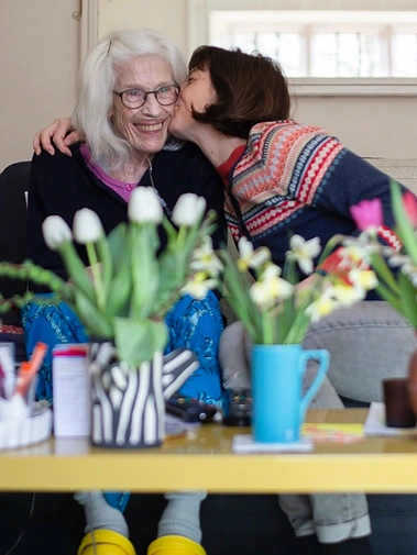daughter giving mum a kiss