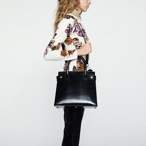 E-commerce catalogue image of female model, Jackie Reyes, wearing a vintage 90s cream long-sleeve cashmere sweater with lavender floral print from Custo Barcelona, black sequin pants, wearing a vintage 1990s black designer Tom Ford Gucci Horsebit bag.