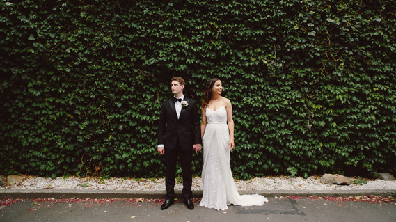 Trendy bride and groom standing in front of ivy wall on wedding day at Museum Hotel, QT Wellington Hotel, New Zealand 