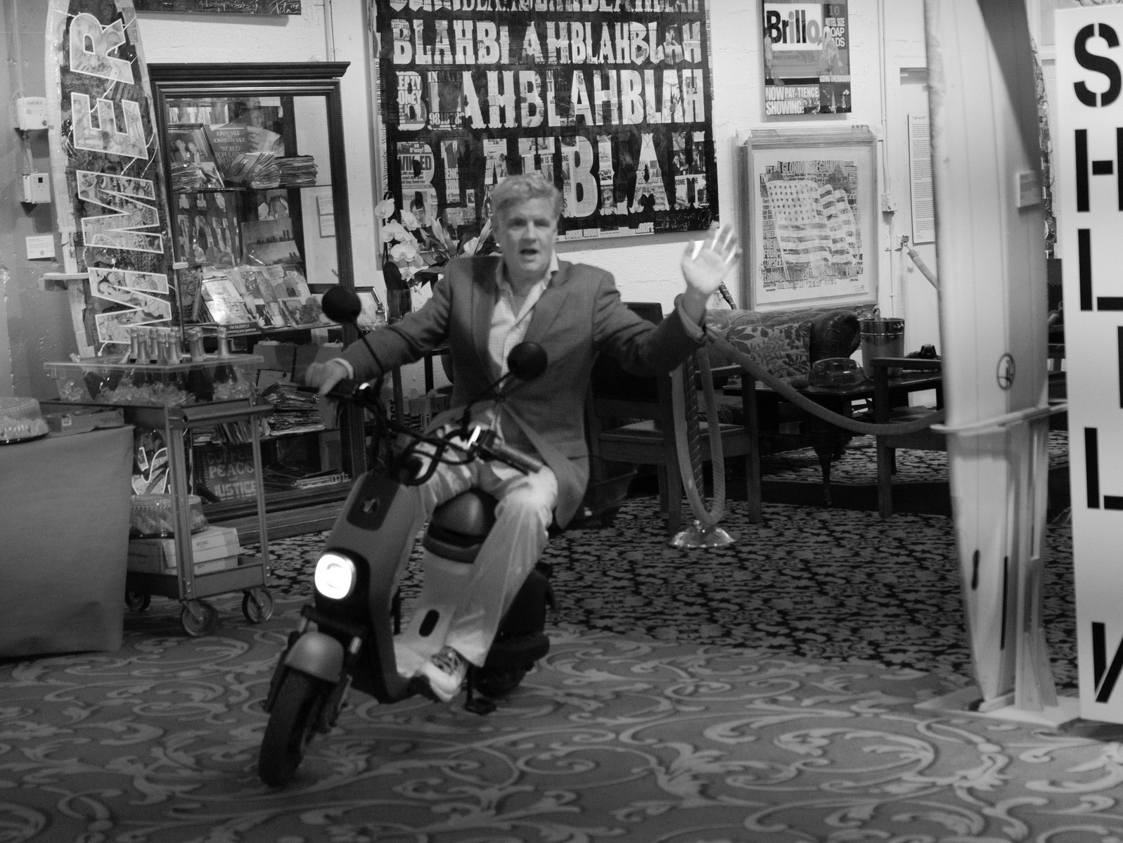 Peter Tunney riding an electric scooter in his art gallery in Miami.
