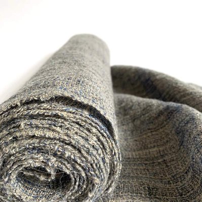 A large roll of handwoven cloth made from belgium unbleached linen with a hint of dark blue wool, by Joost Post