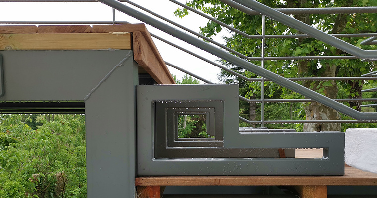 alt=Terrasse en bois avec structure an acier.  Détail marche bois et acier