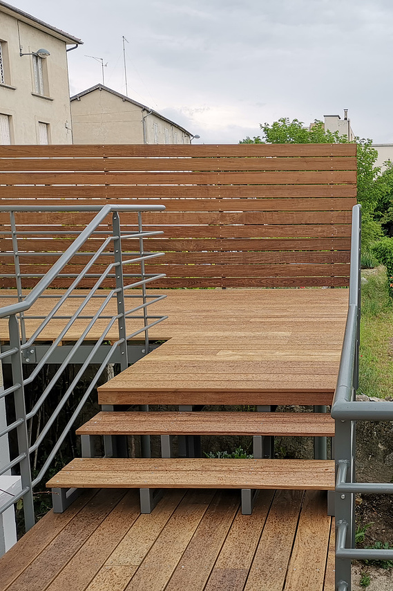alt=Terrasse en bois avec structure an acier.  Détail marche bois et acier