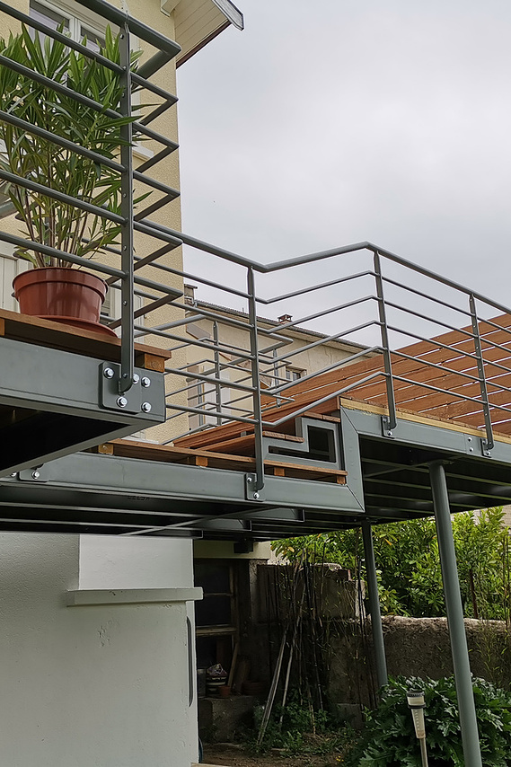 alt=Terrasse en bois avec structure an acier.  Détail marche bois et acier
