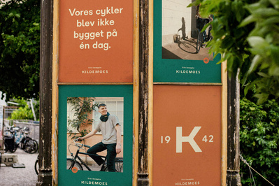 Søjle i grønne omgivelser med reklamer for kildemoes cykler