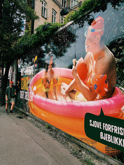 Mand står for enden af stort reklame banner med sun lolly kampagne