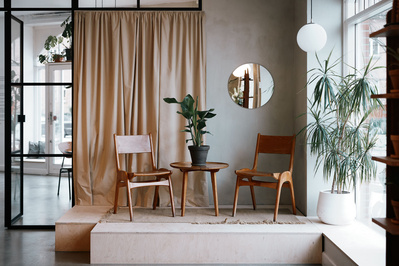 To stole og et bord i en hyggelig cafe med gardin og new Yorker vindue bagved
