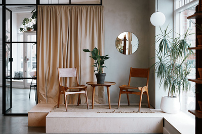 To stole og et bord i en hyggelig cafe med gardin og new Yorker vindue bagved