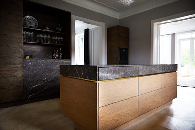Flot køkken med bordplader af marmor og køkkenskabe af træ