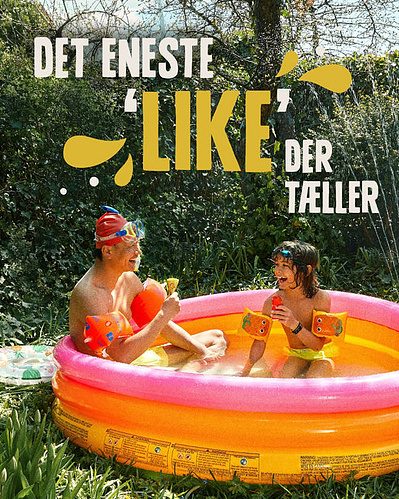 Mand og dreng sidder i badebasin og spiser sun lolly is mens de hygger sig