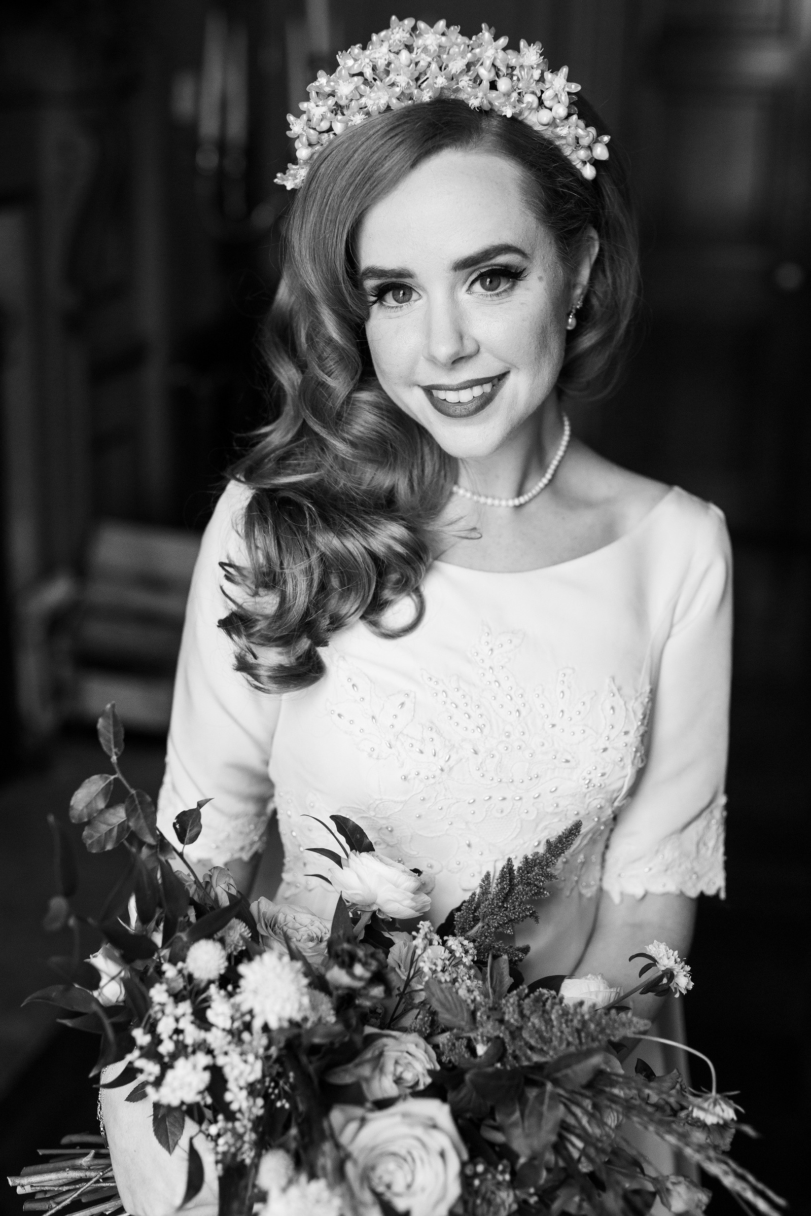 A bride in a vintage gown smiling 