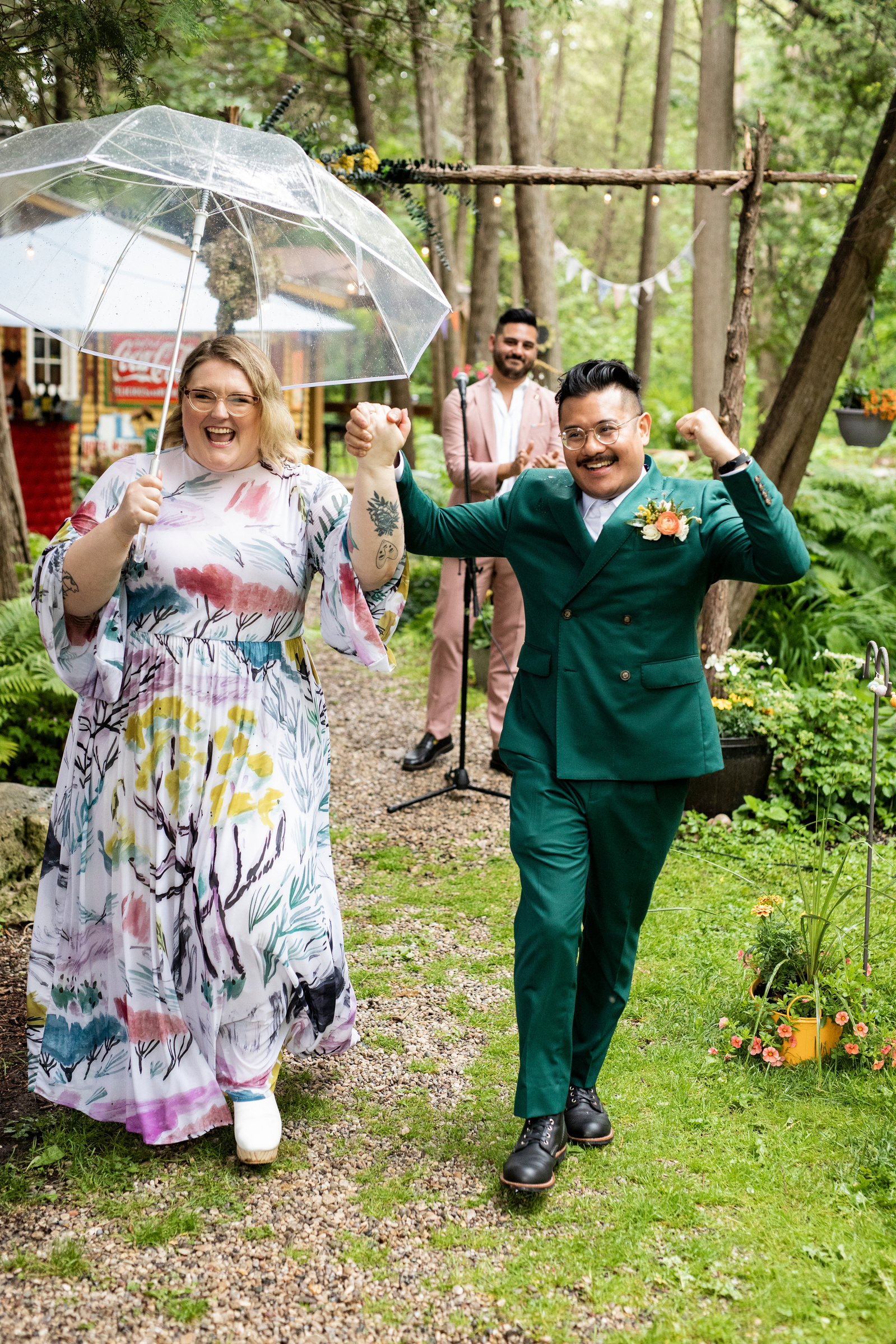 A couple raising their arms in celebration during their wedding processional 