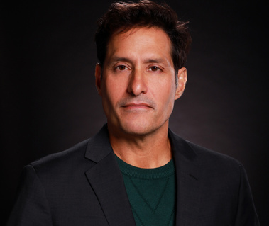 Man wearing a black blazer jacket and green shirt actor headshot