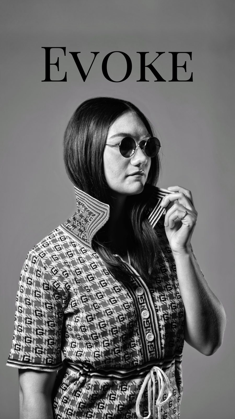 Black and white photo of a model with powerful evokes work overhead. 