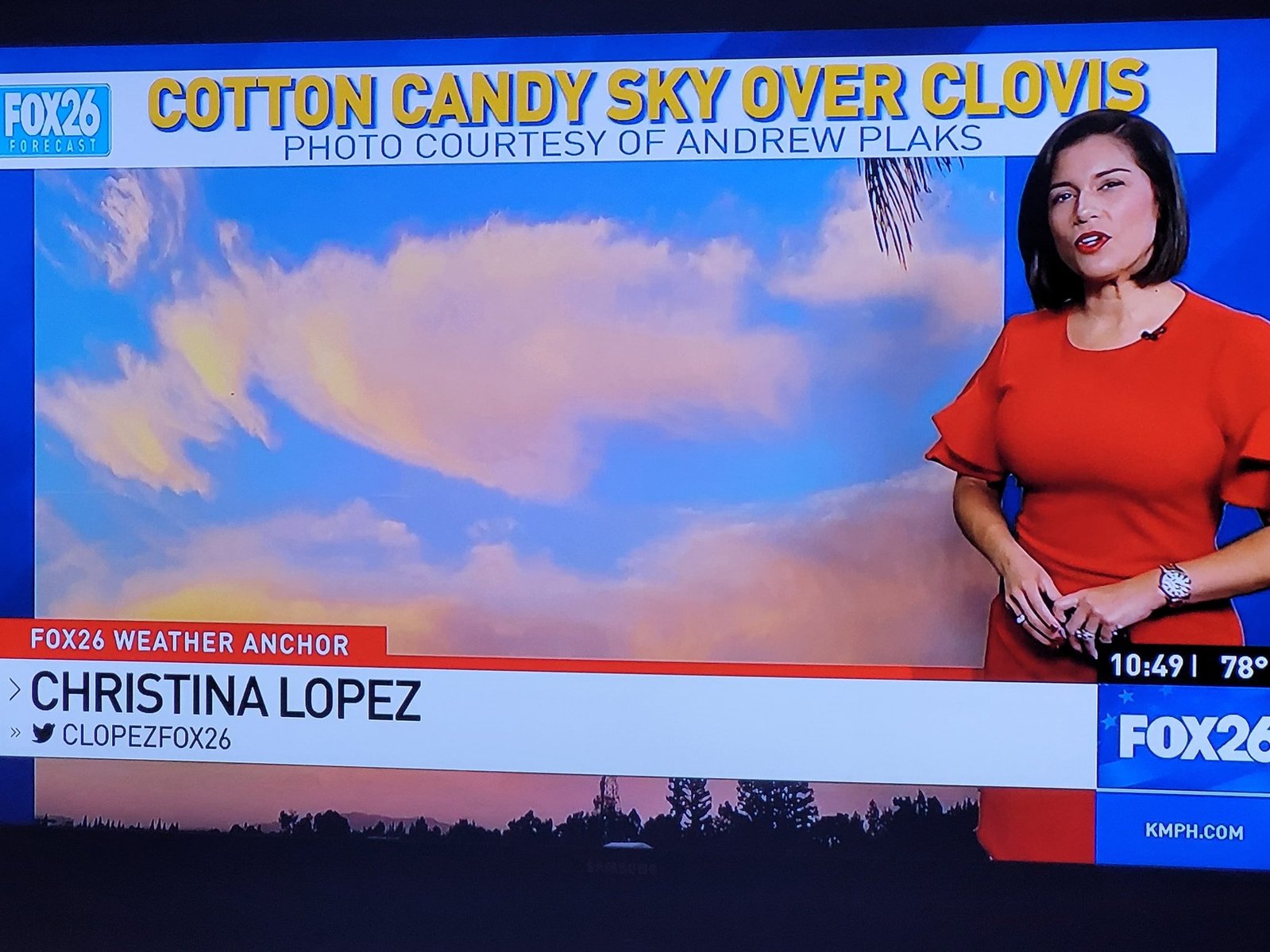 Newscaster gesturing over photo of sunrise. Text above reads: Cotton Candy Sky Over Clovis Photo Courtesy of Andrew Plaks