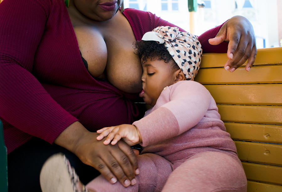 Tomika Spikes (left) breastfeeds Skyler Mathis (right)  in a cable car in San Francisco for Women, Infant, and Children's Breastfeeding Awareness campaign on June 14, 2022. (Karina Patel)