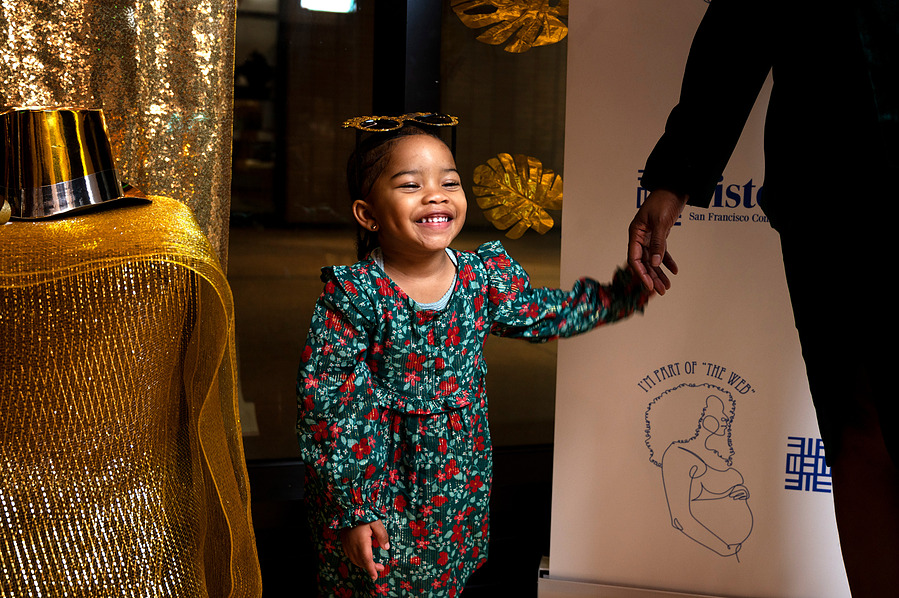 A young girl smiles for the SisterWeb Gala's Step and Repeat in San Francisco on  Dec. 3, 2023. (Karina Patel)