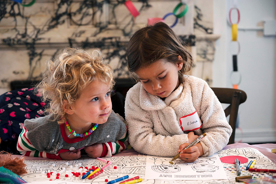 Two girls color at Dollhouse Day, a pop-up started by the Dollhouse Project, at the Hibernia Bank in San Francisco on March 3, 2024. (Karina Patel)