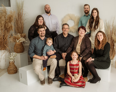 Famille de 10 personnes avec enfants qui prennent la pose durant une séance photo en studio.