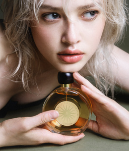 Ukrainian model posing with her favourite perfume: Terracotta le parfum from Guerlain. Beautiful look out of the camera and posing with hands.