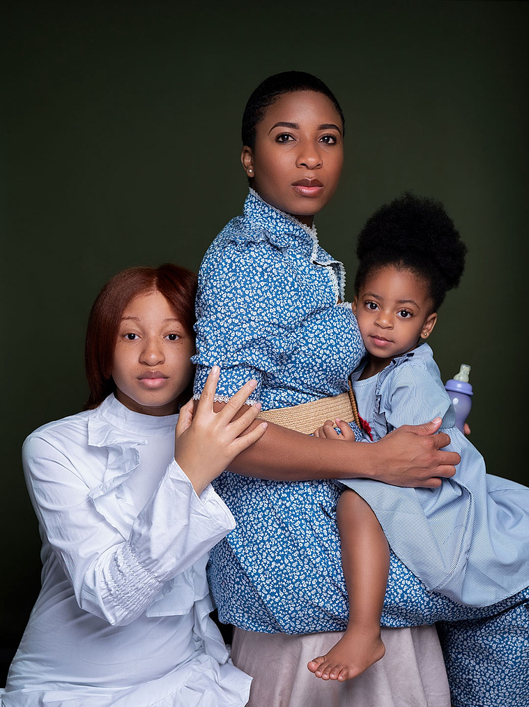 Black mother with her two daughters and a baby bottle