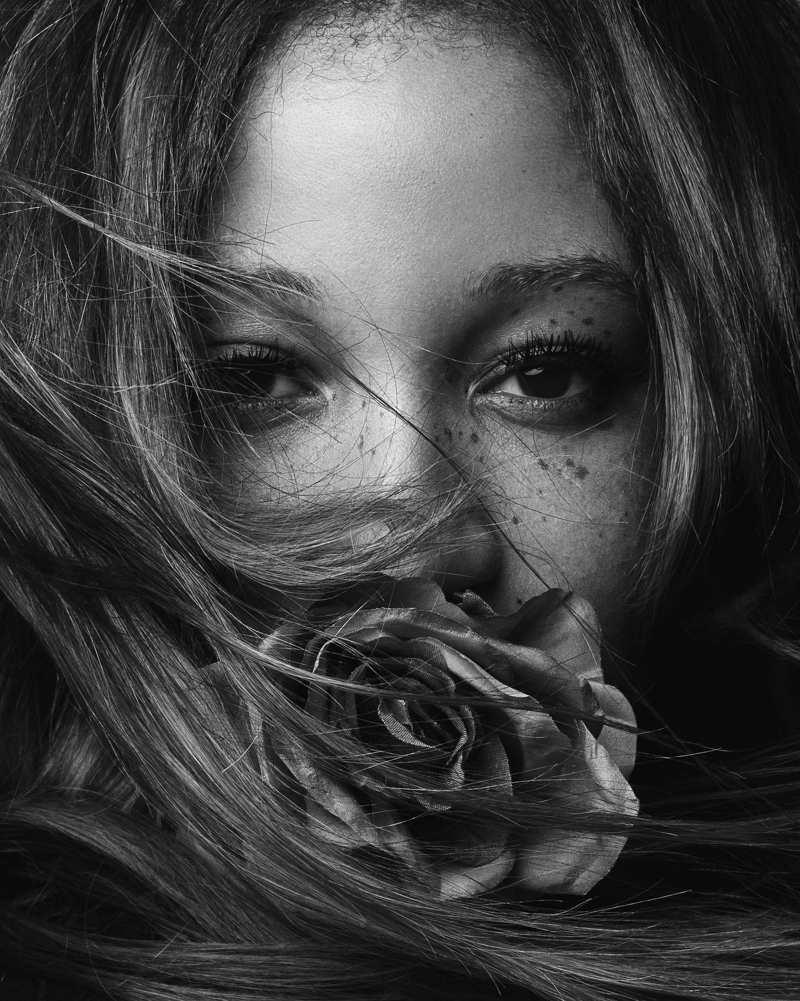 young woman with rose in her mouth