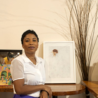 Black female artist and photographer posing with her artwork