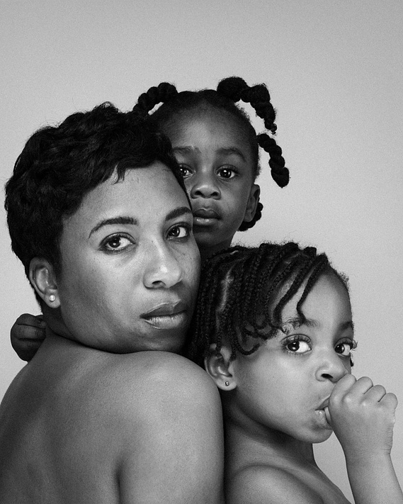 portrait of woman with her baby son and toddler daughter staring into the camera