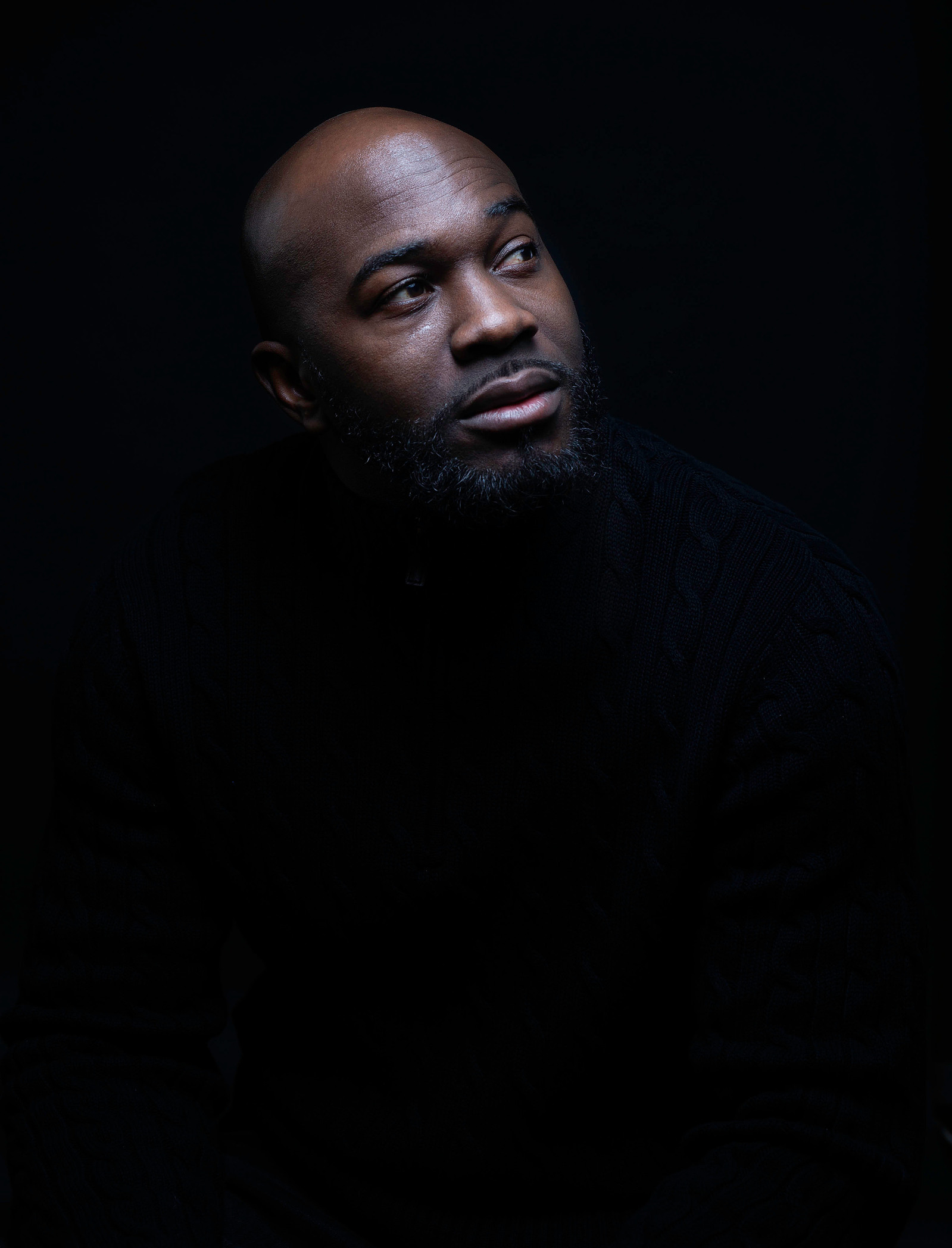 black bald headed man in dark room