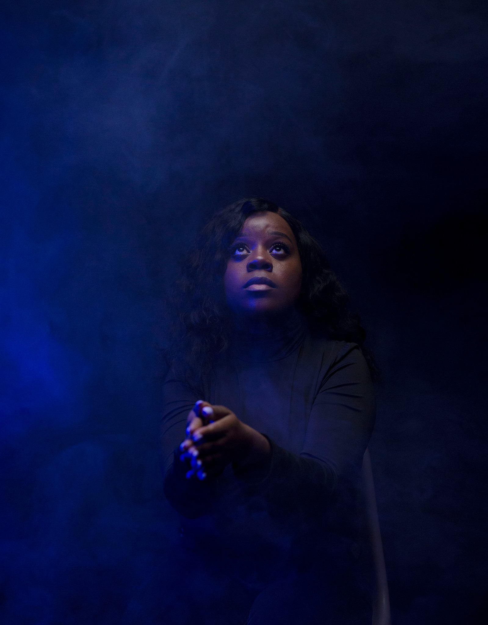 woman in dark room with blue haze
