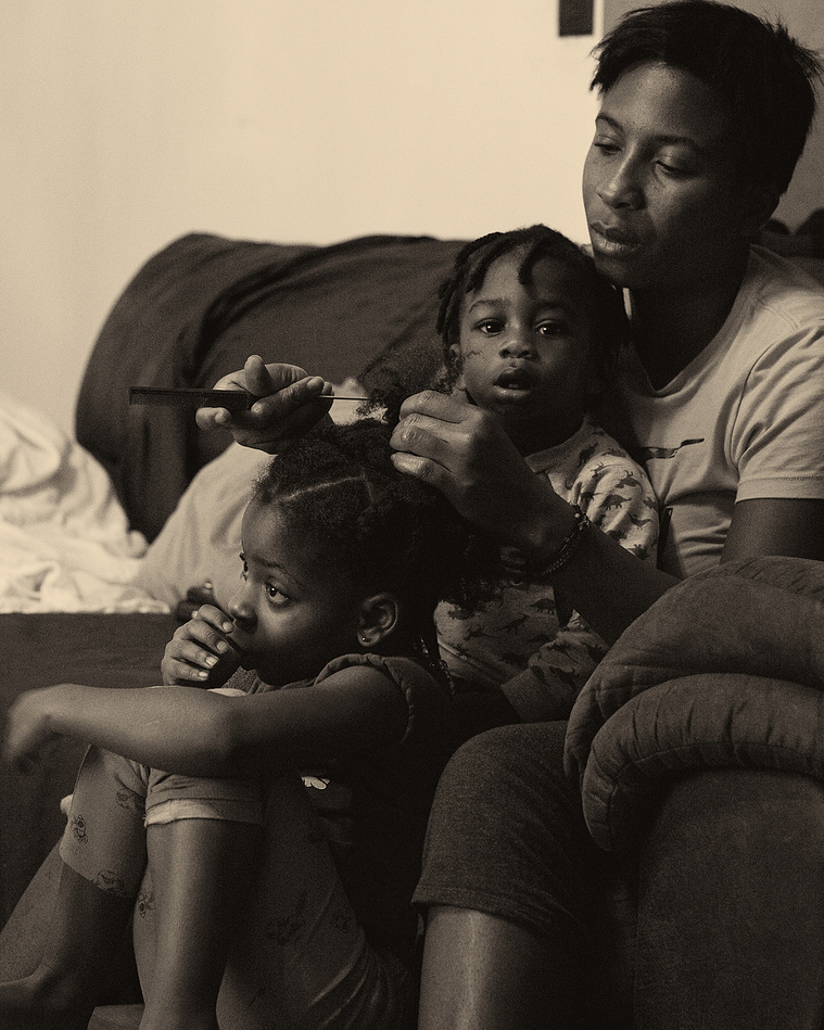 Black woman combing her daughter's hair