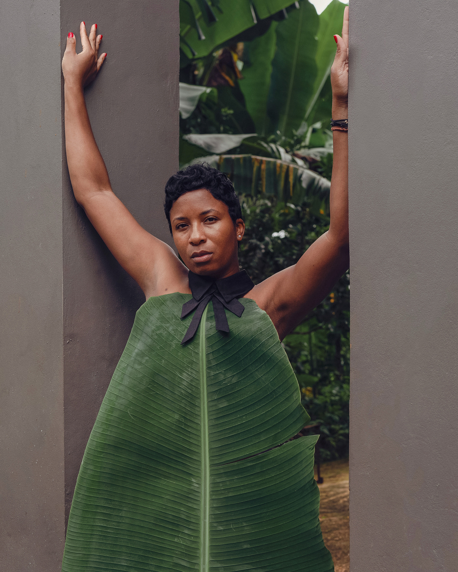 woman standing behind a banana leaf
