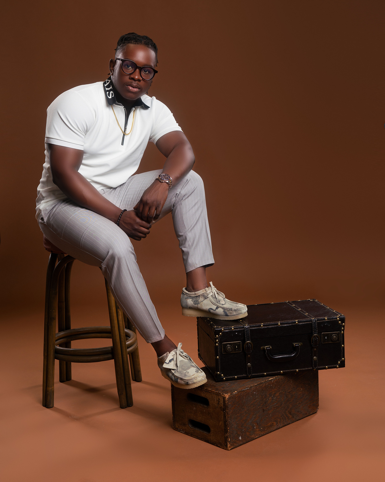 man posing on a wooden stool