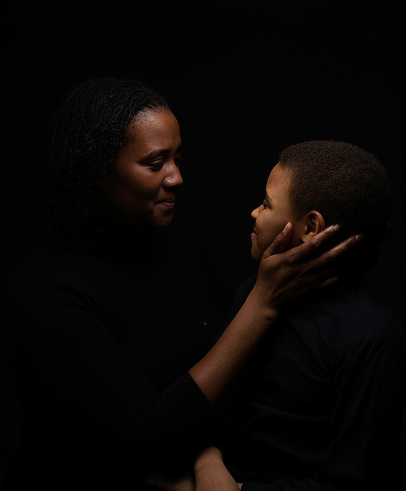 black mother looking at her son while beaming with pride