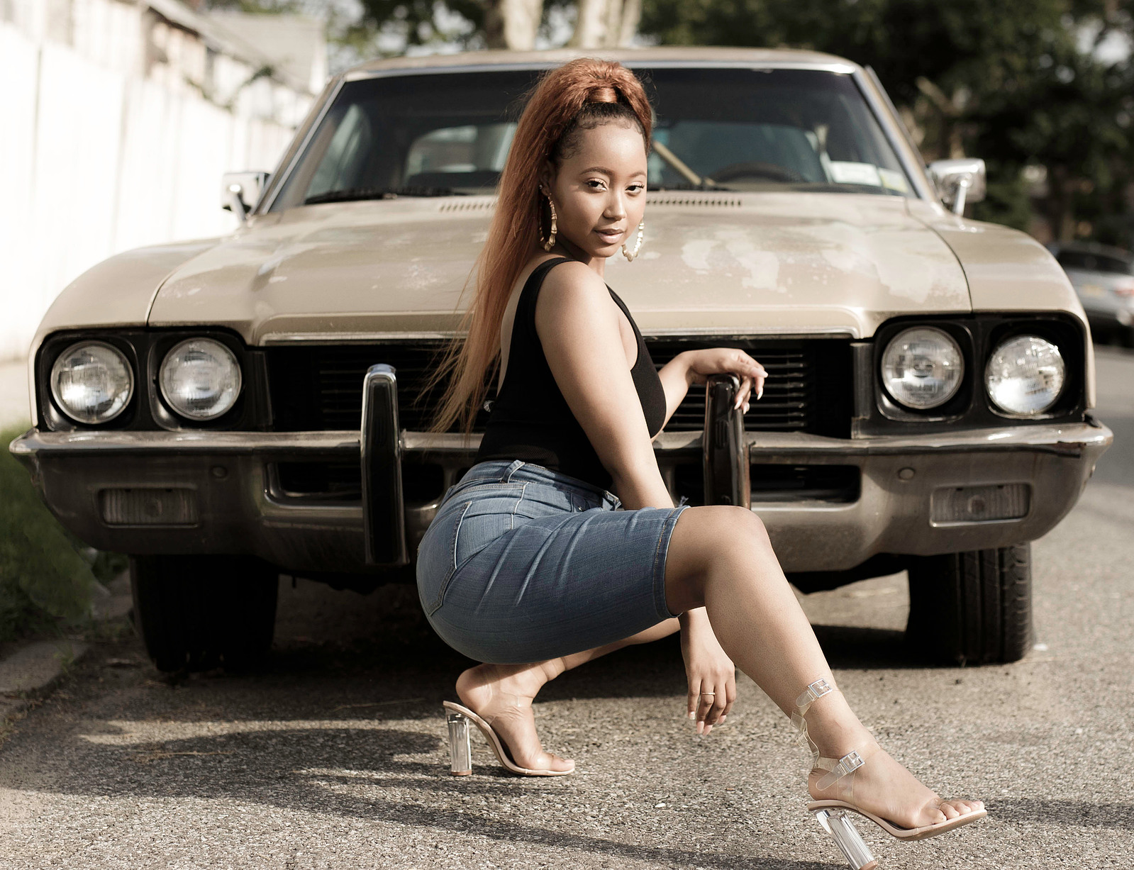 black woman posing in front of a vintage car