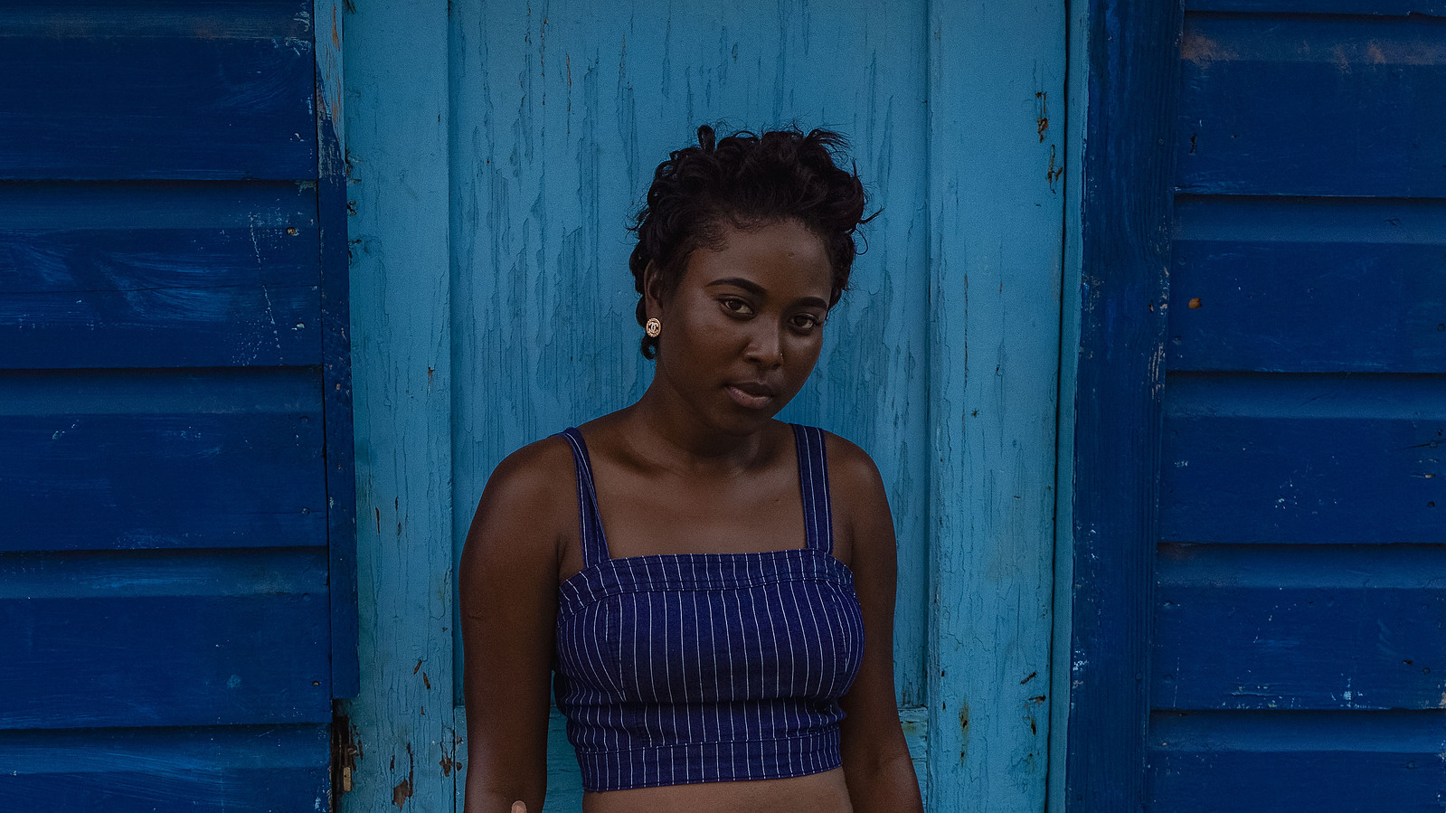 woman wearing blue standing before a blue building