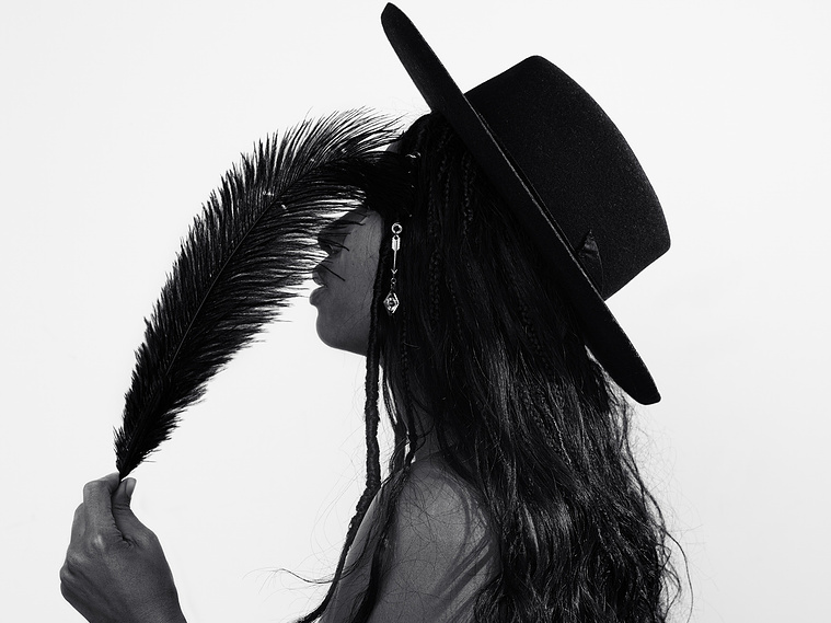 woman with feather covering her face