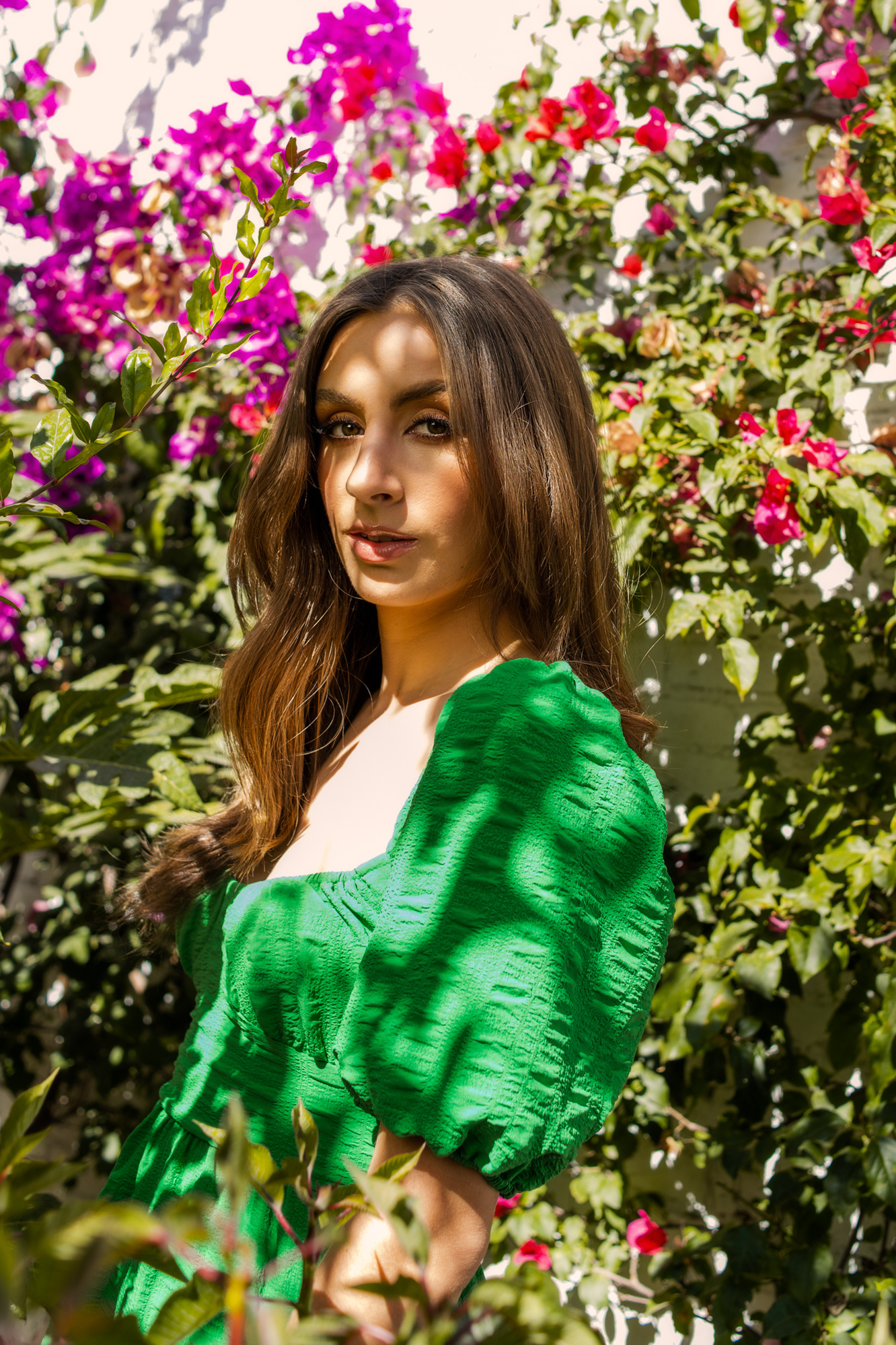 retrato editorial en exterior con modelo en vestido vaporoso verde, maquillaje profesional, en jardín de bugambilias, puebla, méxico