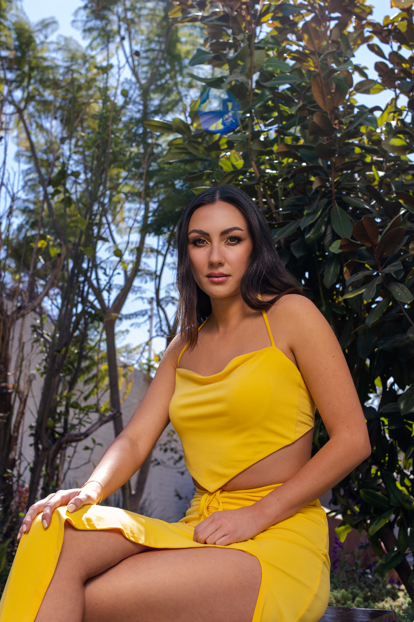 retrato editorial en exterior con modelo en vestido entallado amarillo, maquillaje profesional, a la sombra del árbol, puebla, méxico