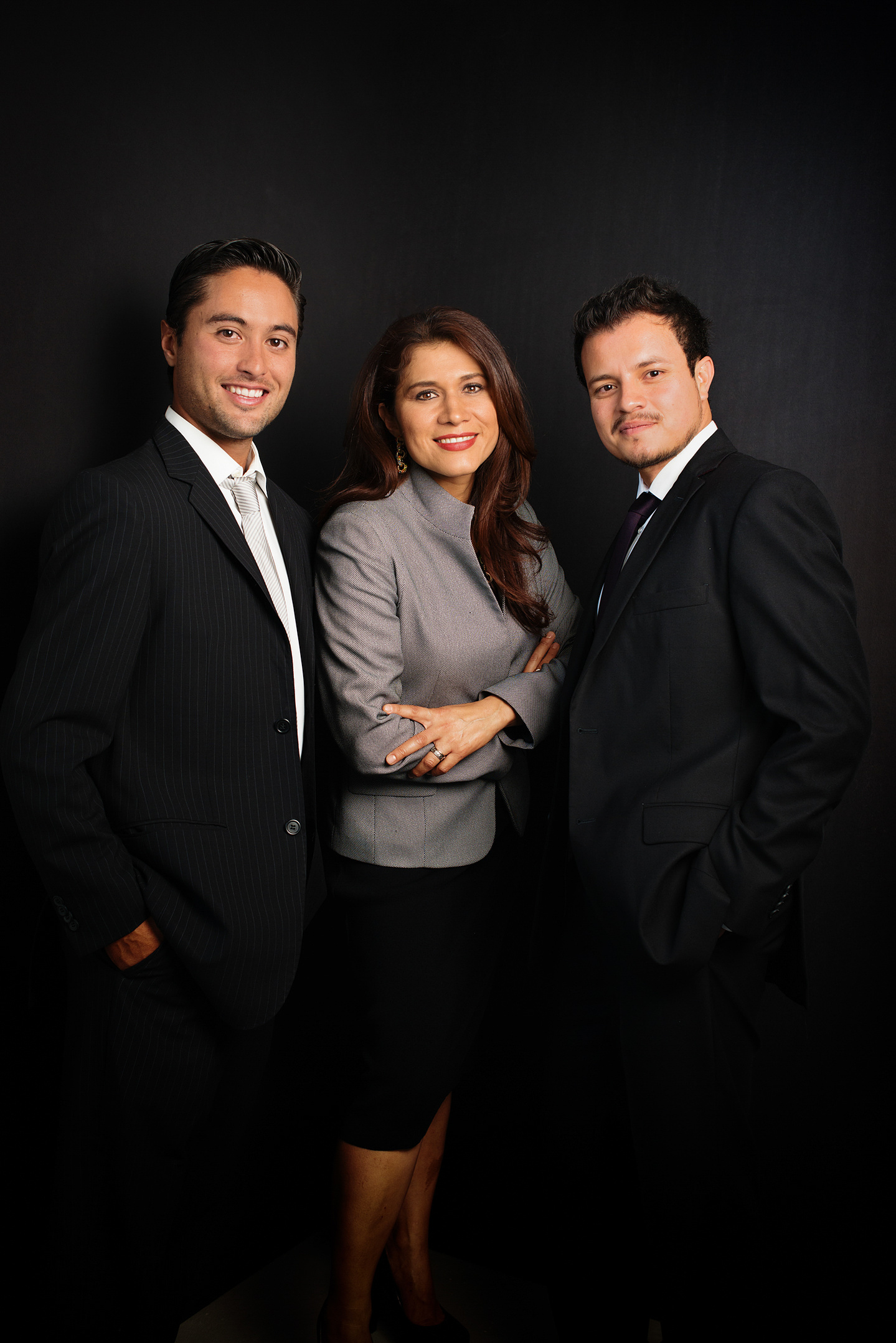retrato corporativo headshot en estudio de equipo de trabajo con atuendo profesional en fondo oscuro, todos de pie