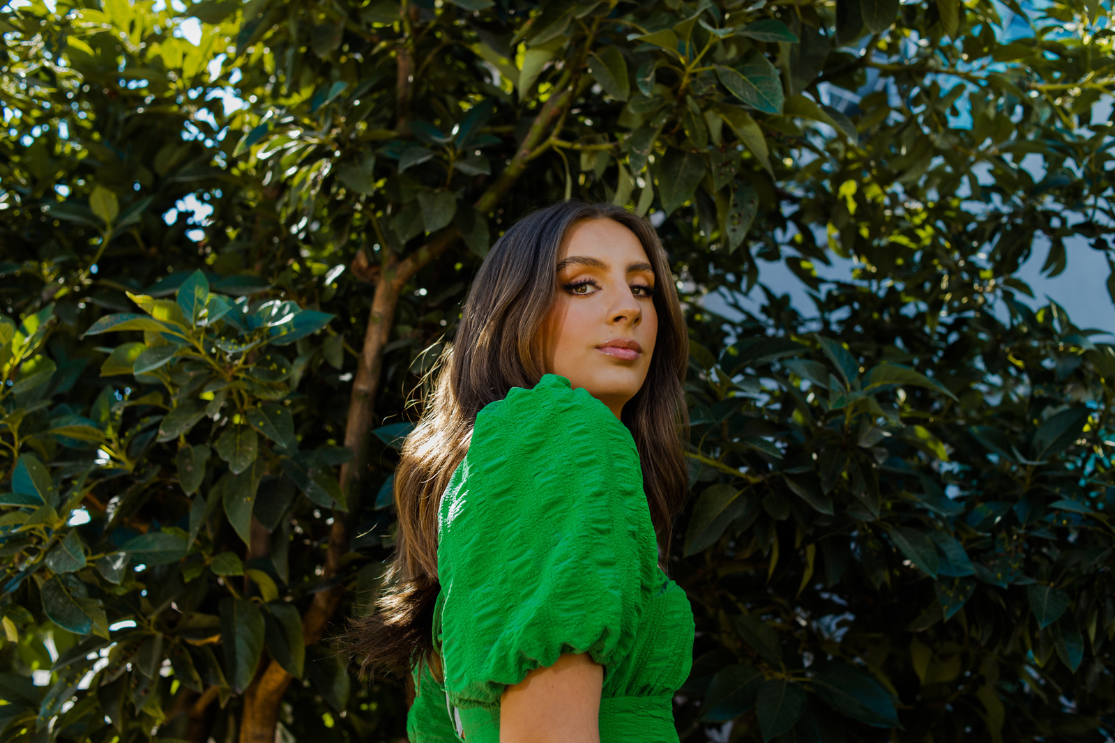 retrato editorial en exterior con modelo en vestido vaporoso verde, maquillaje profesional, a la sombra de un árbol, puebla, méxico