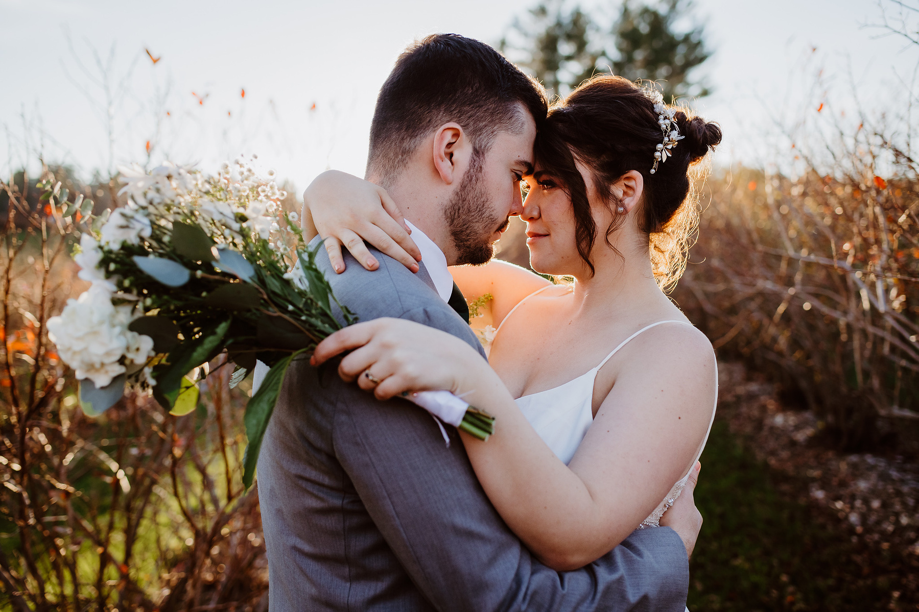 Bride and Groom embracing on their wedding day in a field of grape vines