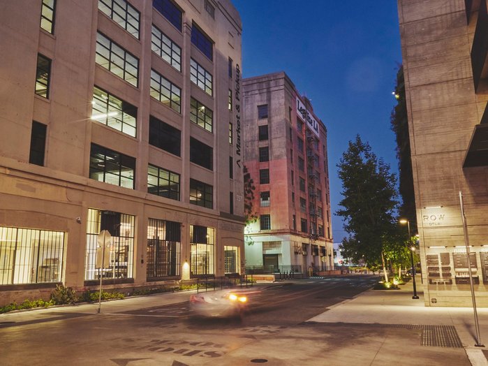 A streetscape of The ROW in Downtown Los Angeles at dusk.