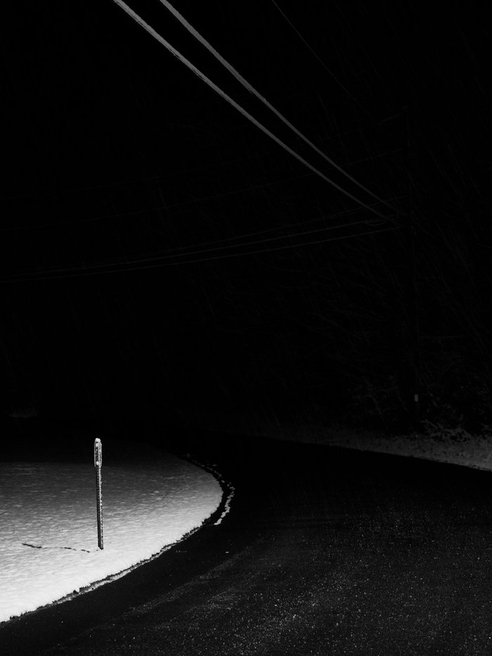 A road disappears into the distance on a dark snowy evening in the Hudson Valley.