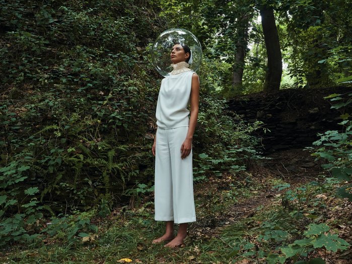 A woman standing in a cavern with a decorative collar and a glass bubble shaped helmet surrounding her head. Shot on Olympus EM1mkiii