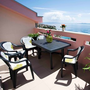 photo of view from arc rentals properties with a seaview in split croatia from an apartment rental on ciovo with a terrace and balcony with sunloungers and green fern and orange fern
