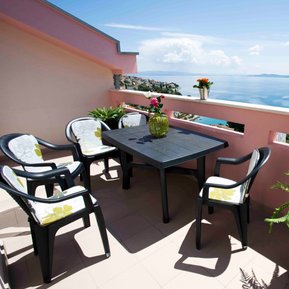 photo of view from arc rentals properties with a seaview in split croatia from an apartment rental on ciovo with a terrace and balcony with sunloungers and green fern and orange fern